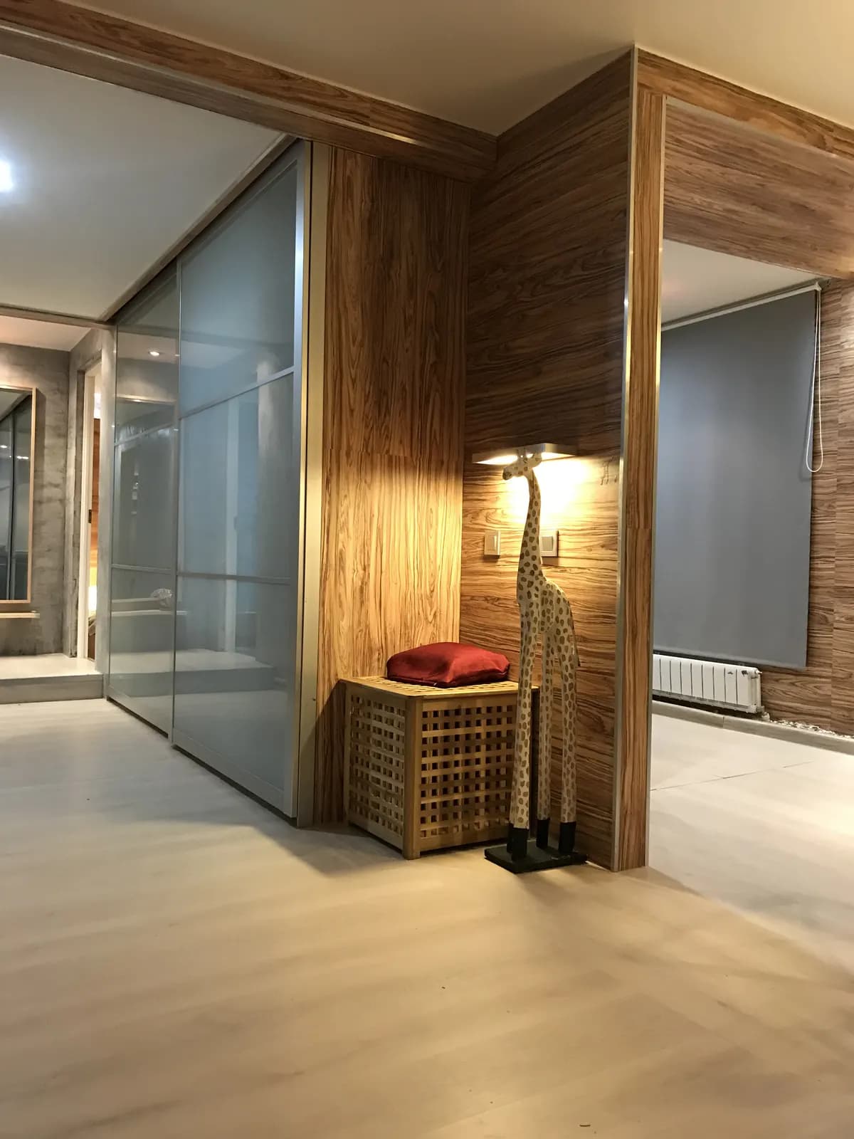 Frosted glass sliding partition beside a walnut panelled hallway