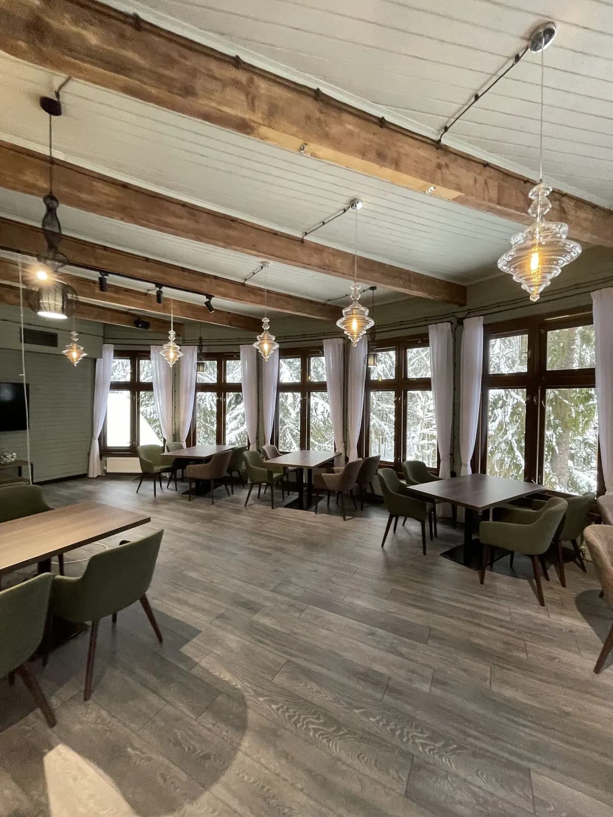 Timber frame restaurant dining room with sage walls and glass pendant lights